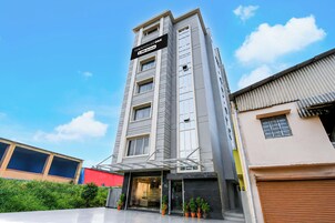 Un edificio de varios pisos con un cartel que indica que cuenta con servicios de OYO.