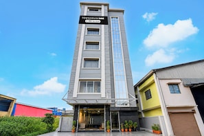 A multi-story building with a sign indicating it is serviced by OYO.
