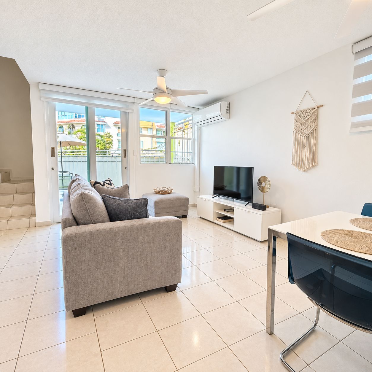 A modern living room with a sofa, TV, and dining table.