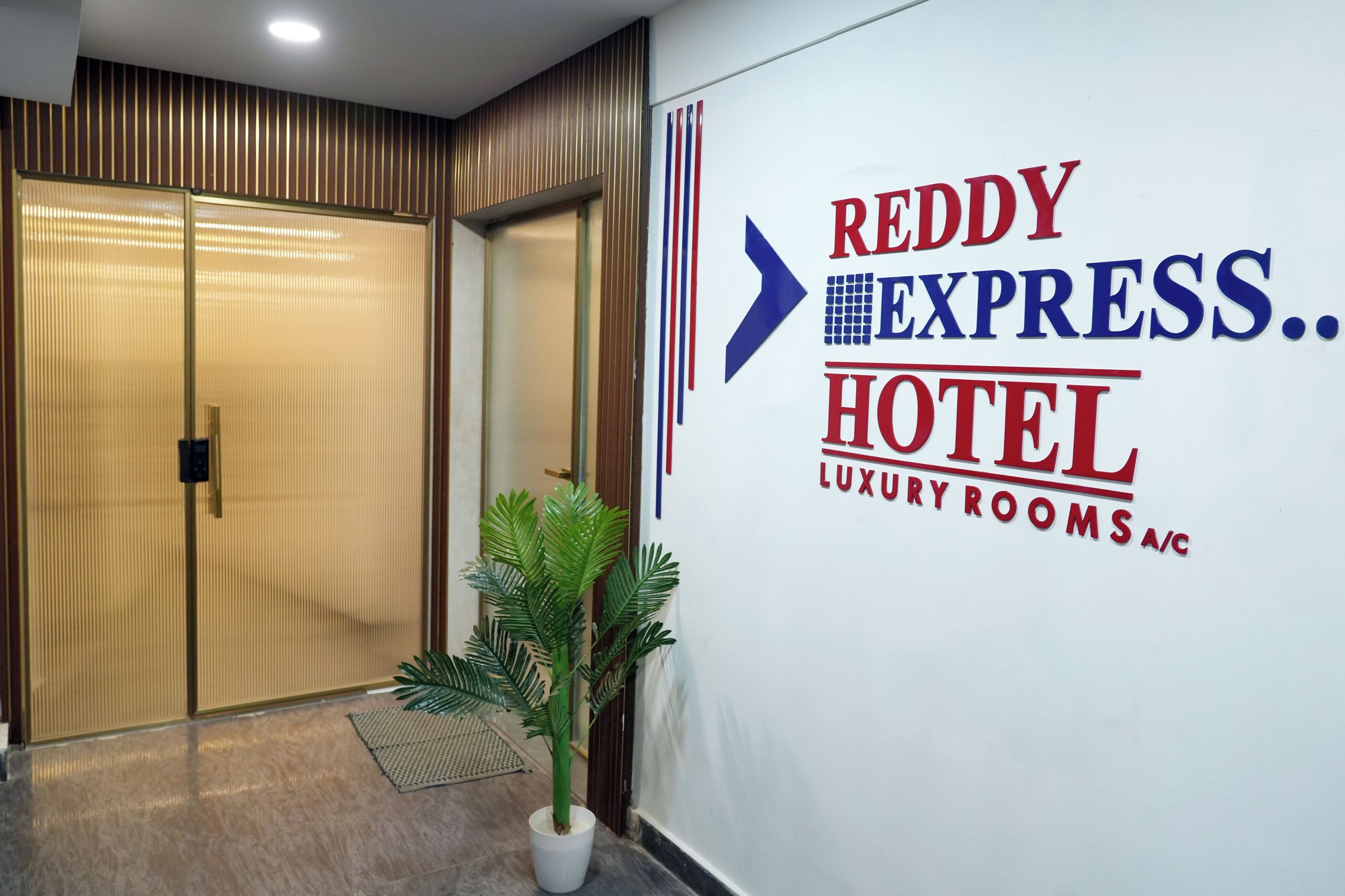 Entrada de un hotel con un letrero que dice 'Reddy Express.. HABITACIONES DE LUJO CON AIRE ACONDICIONADO HOTEL'.