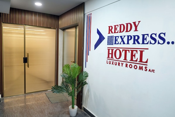 A hotel entrance with a sign for 'Reddy Express.. HOTEL LUXURY ROOMS A/C'.