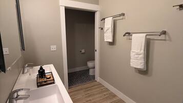 A bathroom with a white sink, two towel racks, and a mirror.