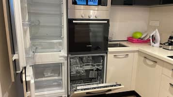 Una cocina equipada con lavavajillas, microondas y fregadero.
