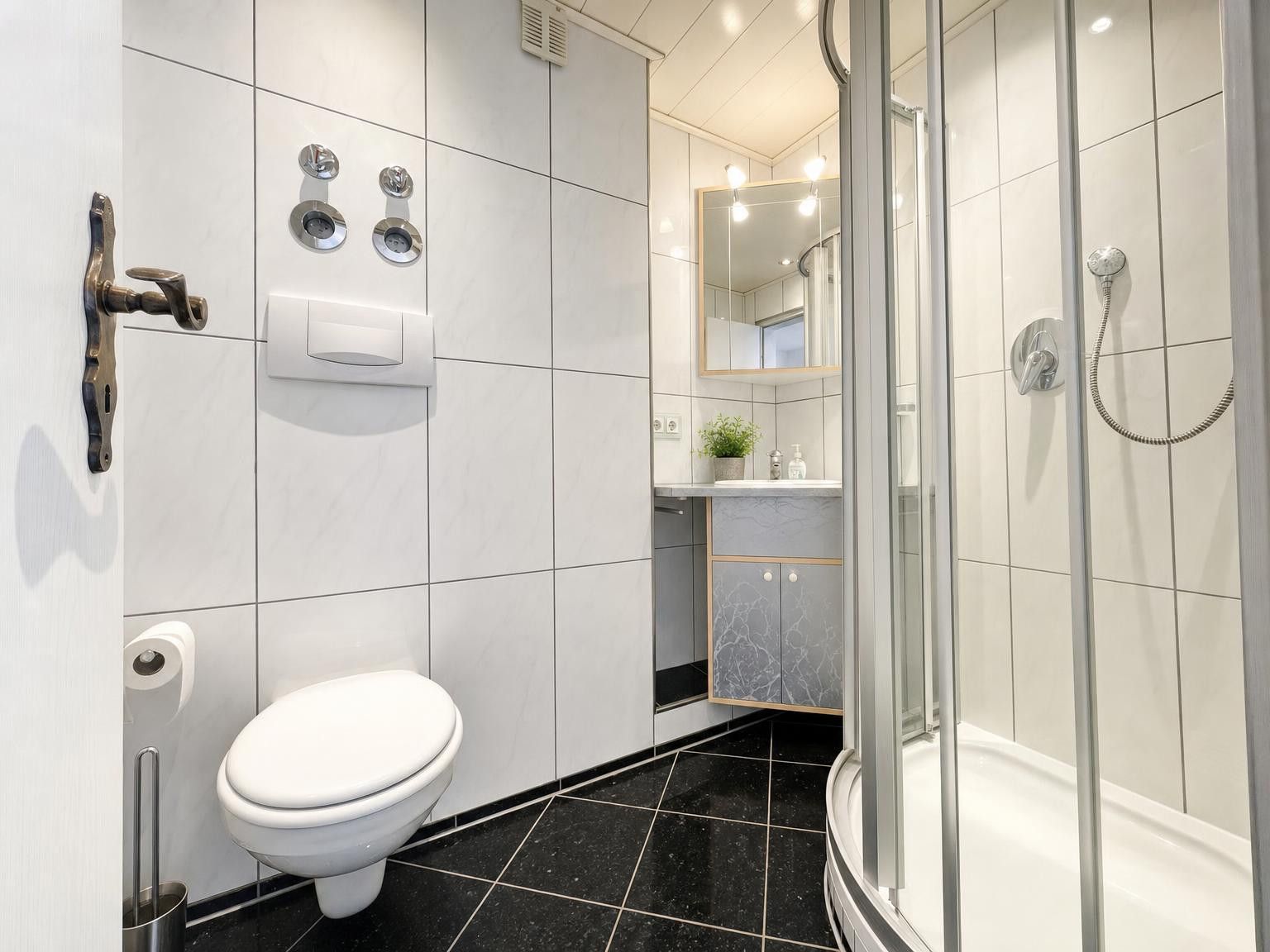 Ein modernes Badezimmer mit Toilette, Dusche und Waschbecken.
