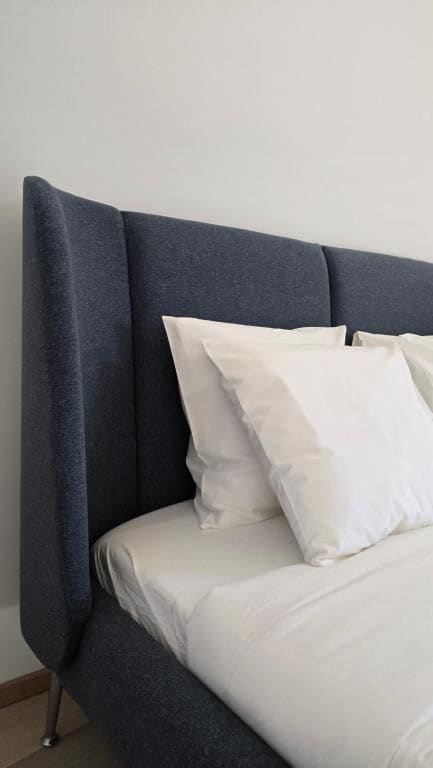 A bed with a dark headboard and white bedding.
