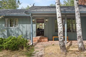 A house with a front porch, a brick entrance, and a window overlooking the yard. - Cozy Retro Aspen Home, 5 Min to Downtown & Trails (Aspen)