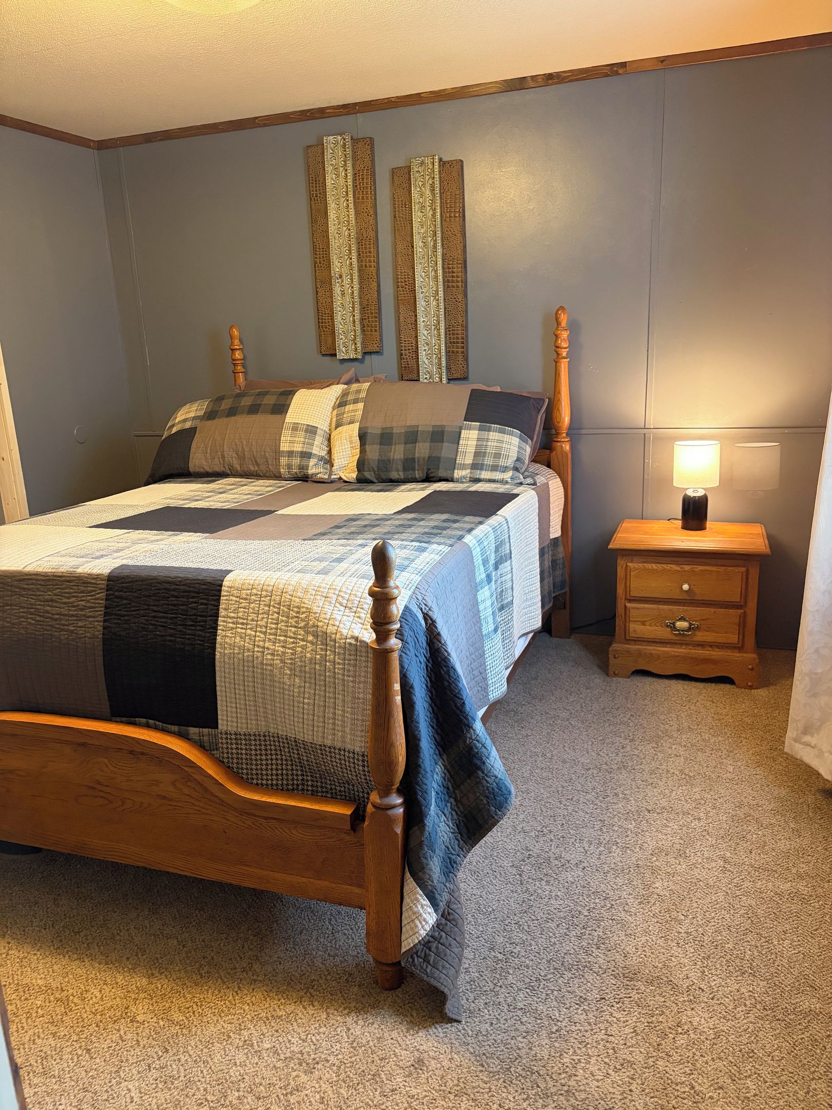 Une chambre à coucher avec un lit en bois, une table de chevet avec une lampe et des panneaux décoratifs sur les murs.