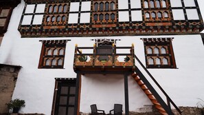 A building with a balcony, a door, and a staircase. - Sonam's Farm House Paro (Paro)