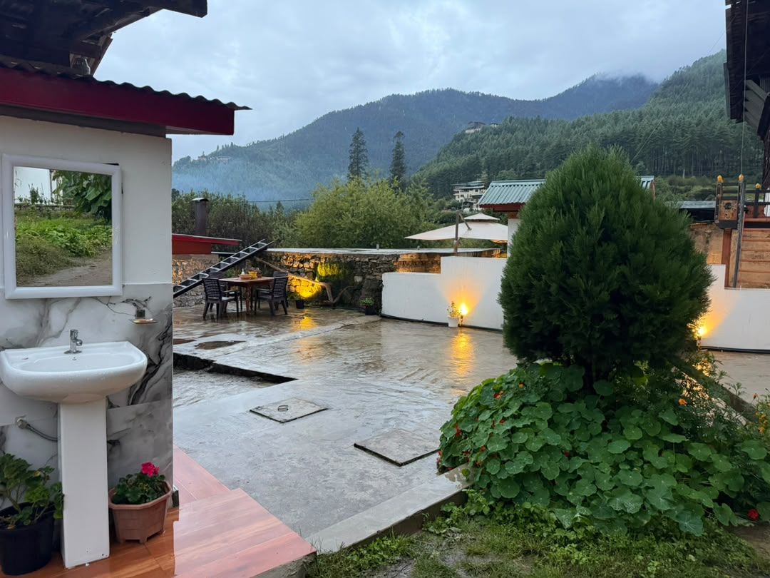 Terraza en la azotea con lavamanos, asientos al aire libre y vistas a las montañas.