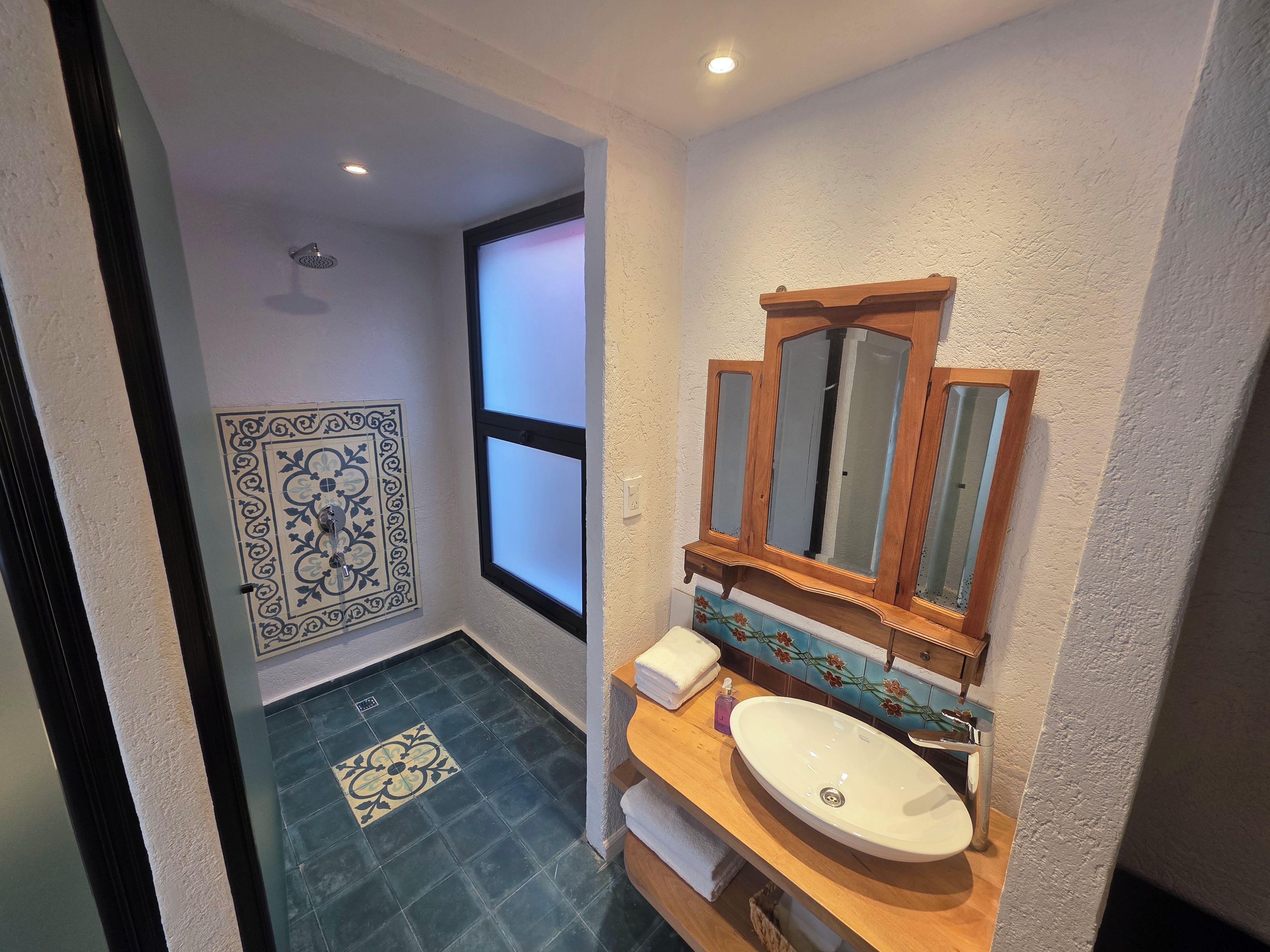 Une salle de bain avec un meuble-lavabo en bois, un lavabo blanc et un grand miroir.
