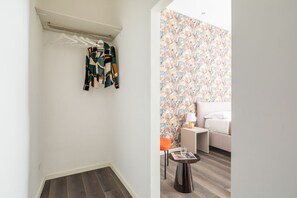 Ein Zimmer mit einem Bett, einem Nachttisch, einer Lampe und einer Zeitschrift auf einem Tisch.