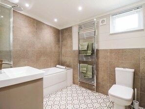 Ein Badezimmer mit einer Badewanne, Toilette und einem Handtuchhalter.