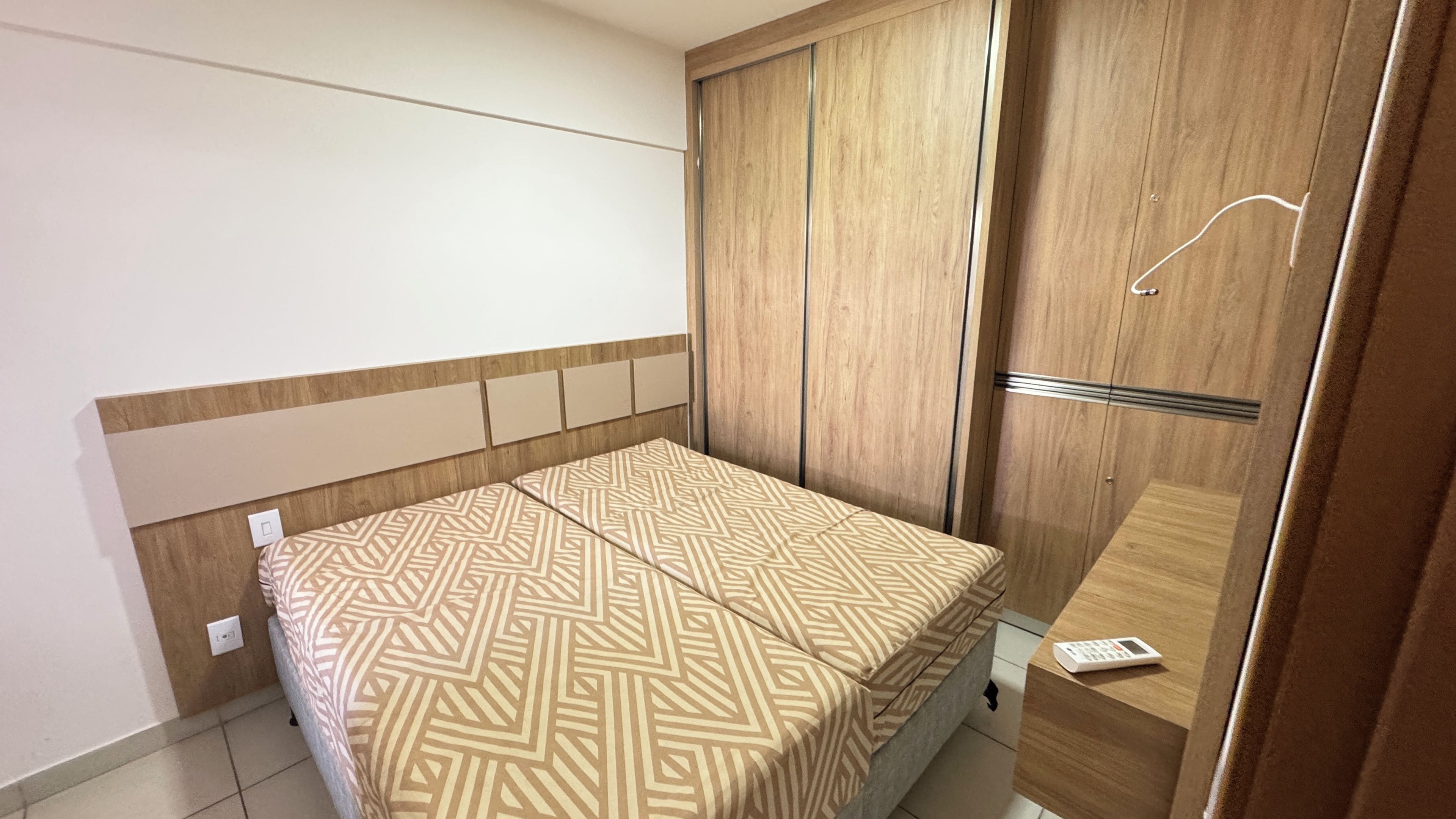 Une chambre à coucher avec un lit, une armoire et une petite table de chevet.