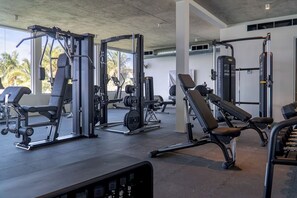 Una palestra con diverse macchine per esercizi, panche e rastrelliere per pesi.