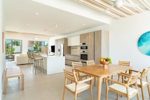 Une cuisine moderne avec des meubles en bois, un îlot central et un coin repas doté de chaises en bois.