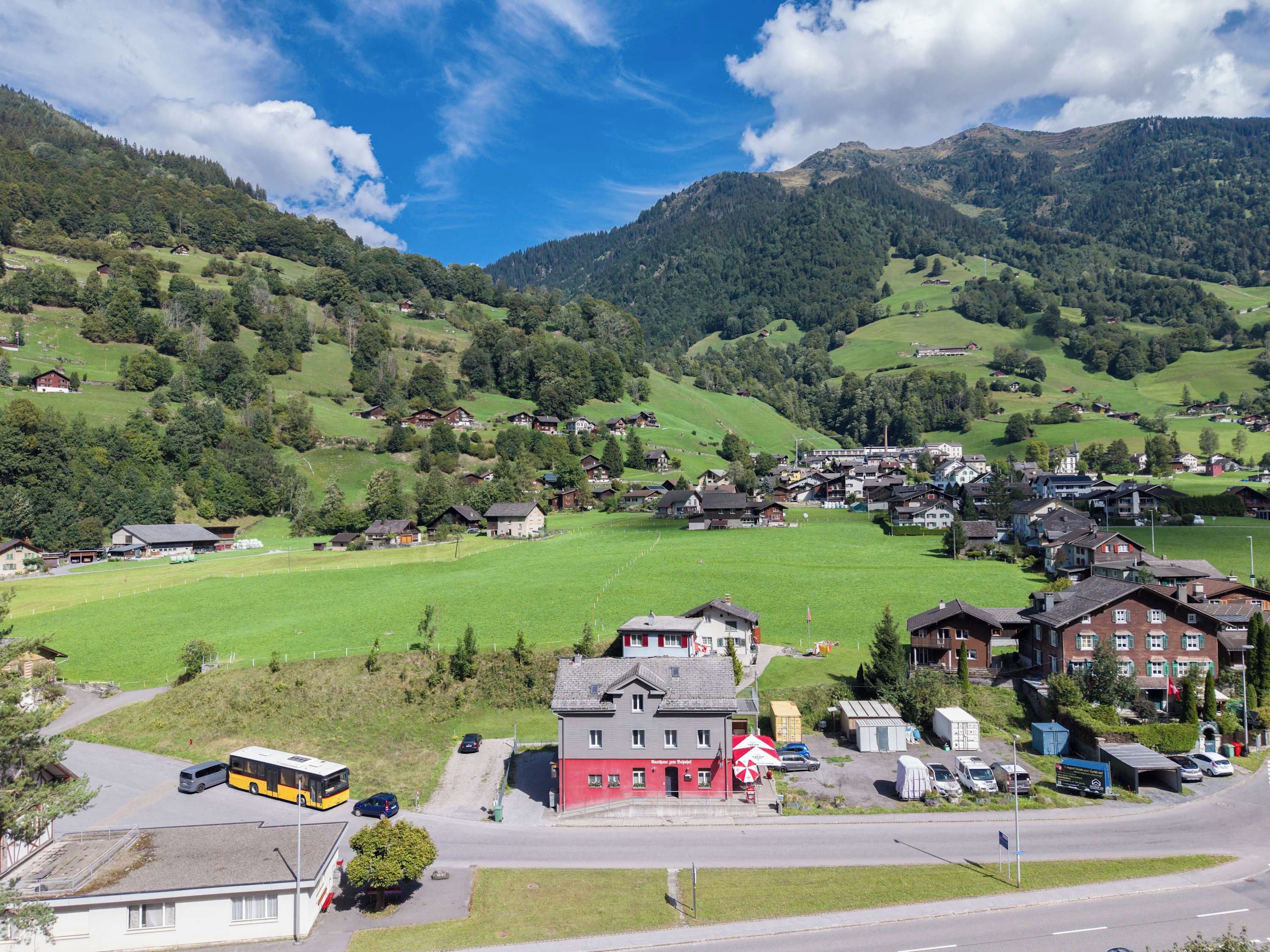 A rural village with houses, a bus station, and a road.