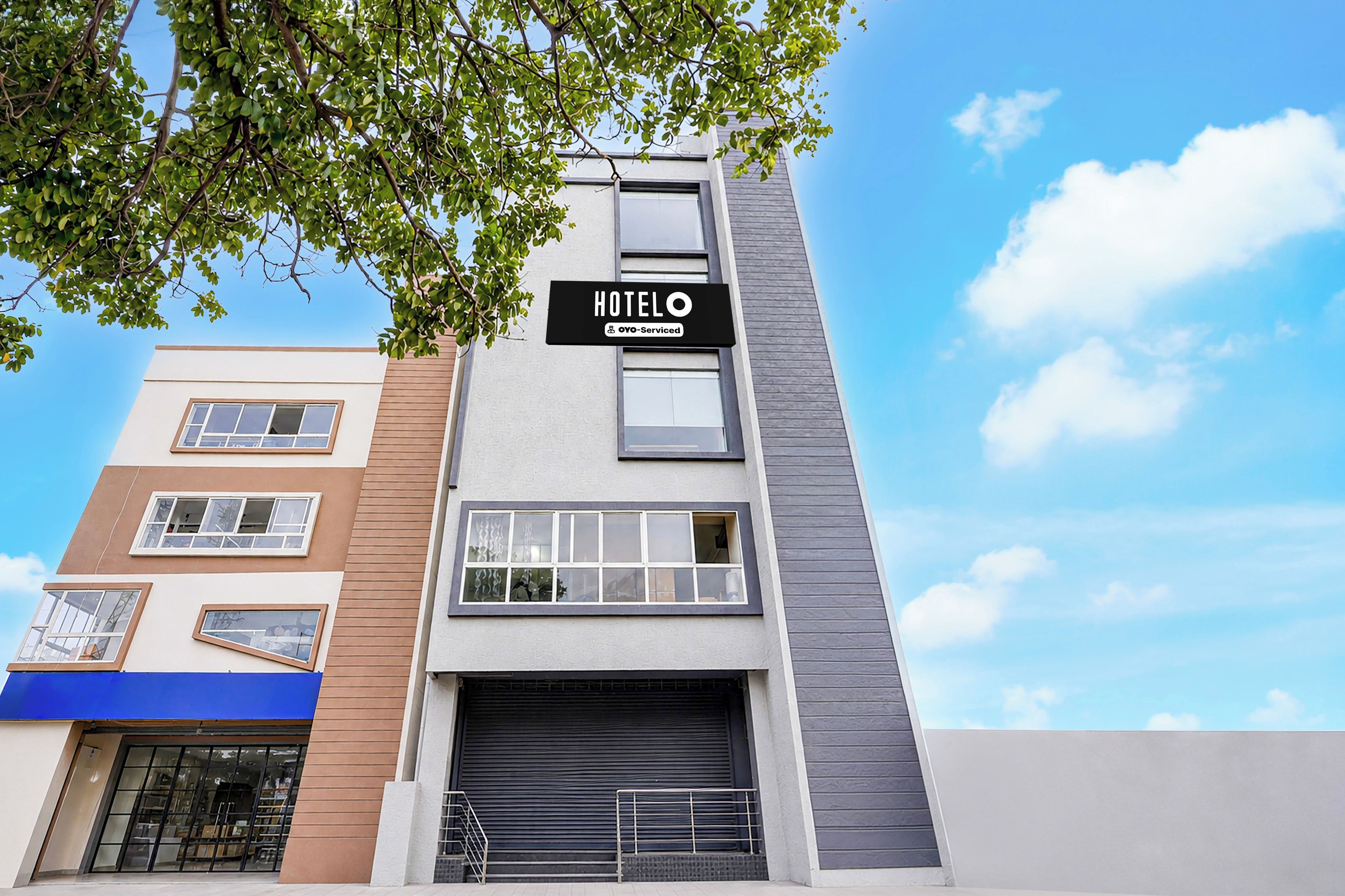 A multi-story hotel with a sign indicating it is serviced by OYO.