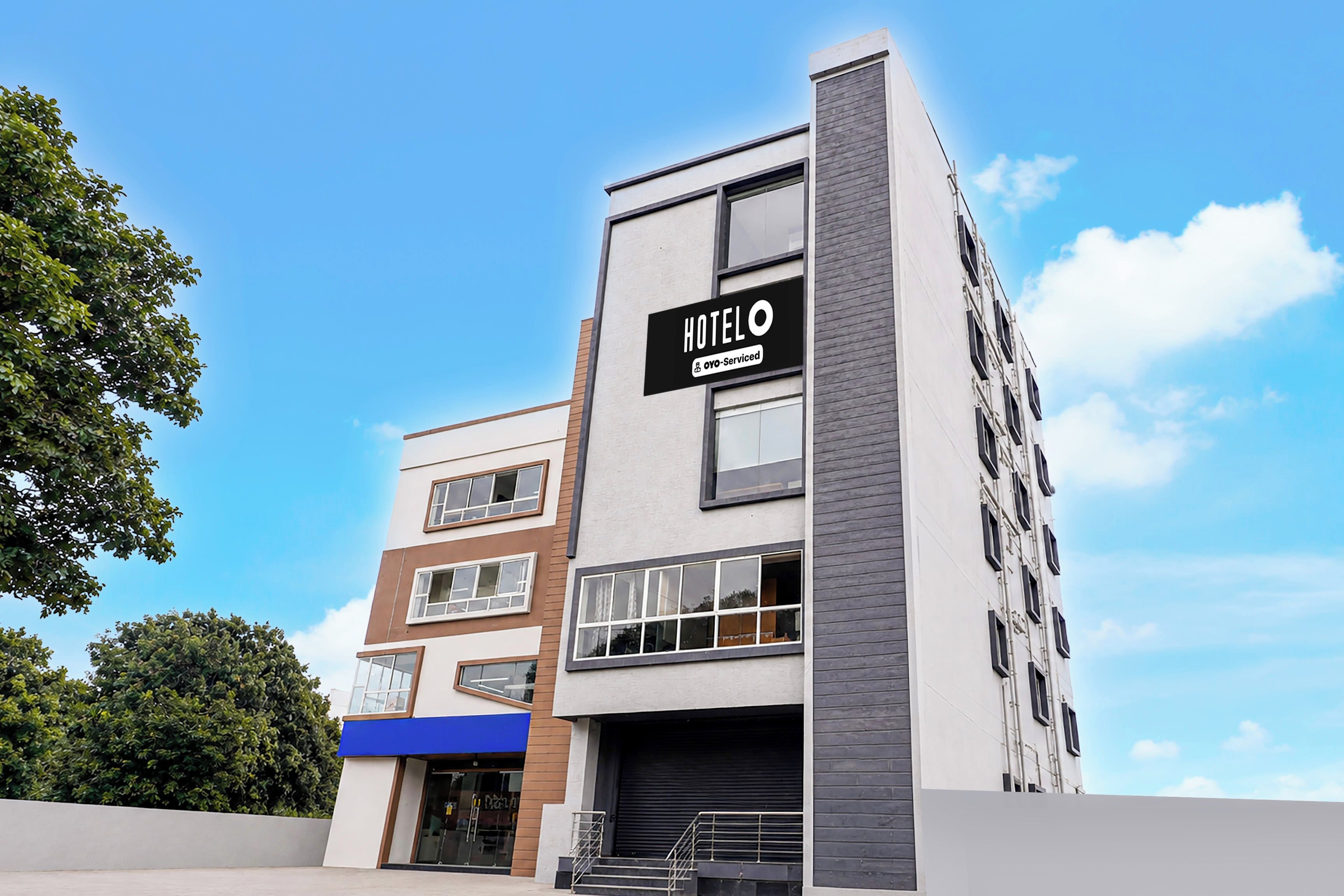 A modern hotel building with a sign indicating it is serviced by OYO.