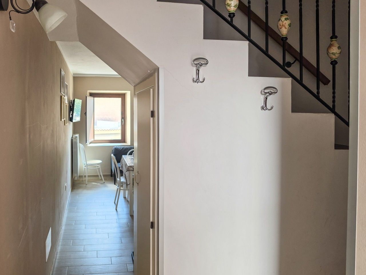Ein Flur mit Treppe, einem Sessel und einem Tisch.