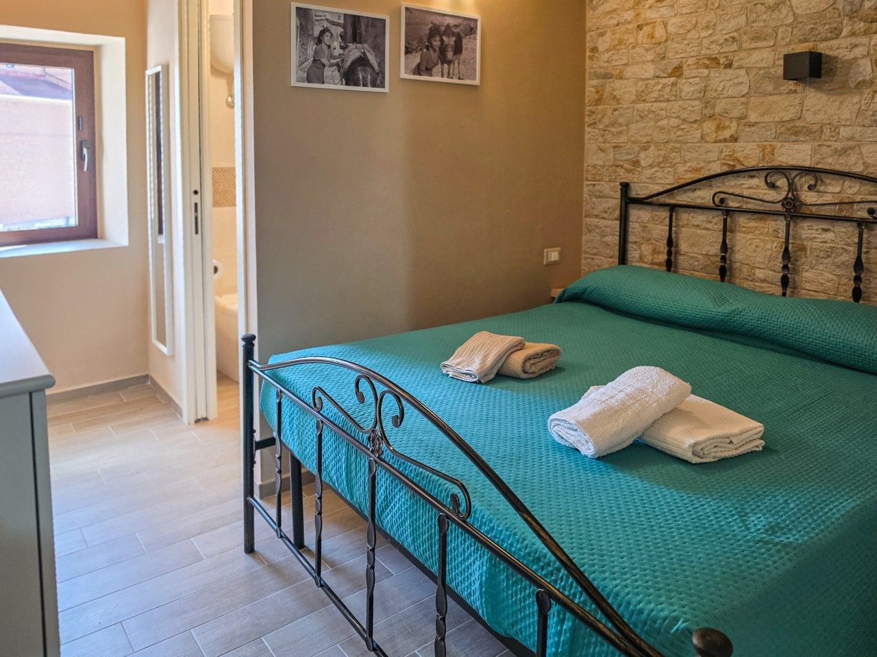 Une chambre à coucher avec un lit, un mur en pierre et une porte.