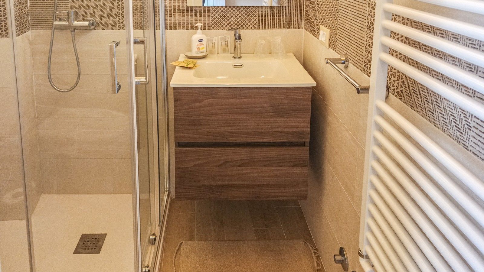 Une salle de bain avec une douche, un lavabo et un miroir.
