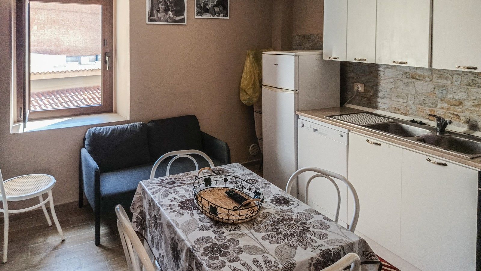 Una cucina compatta con tavolo, sedie, frigorifero e lavello.