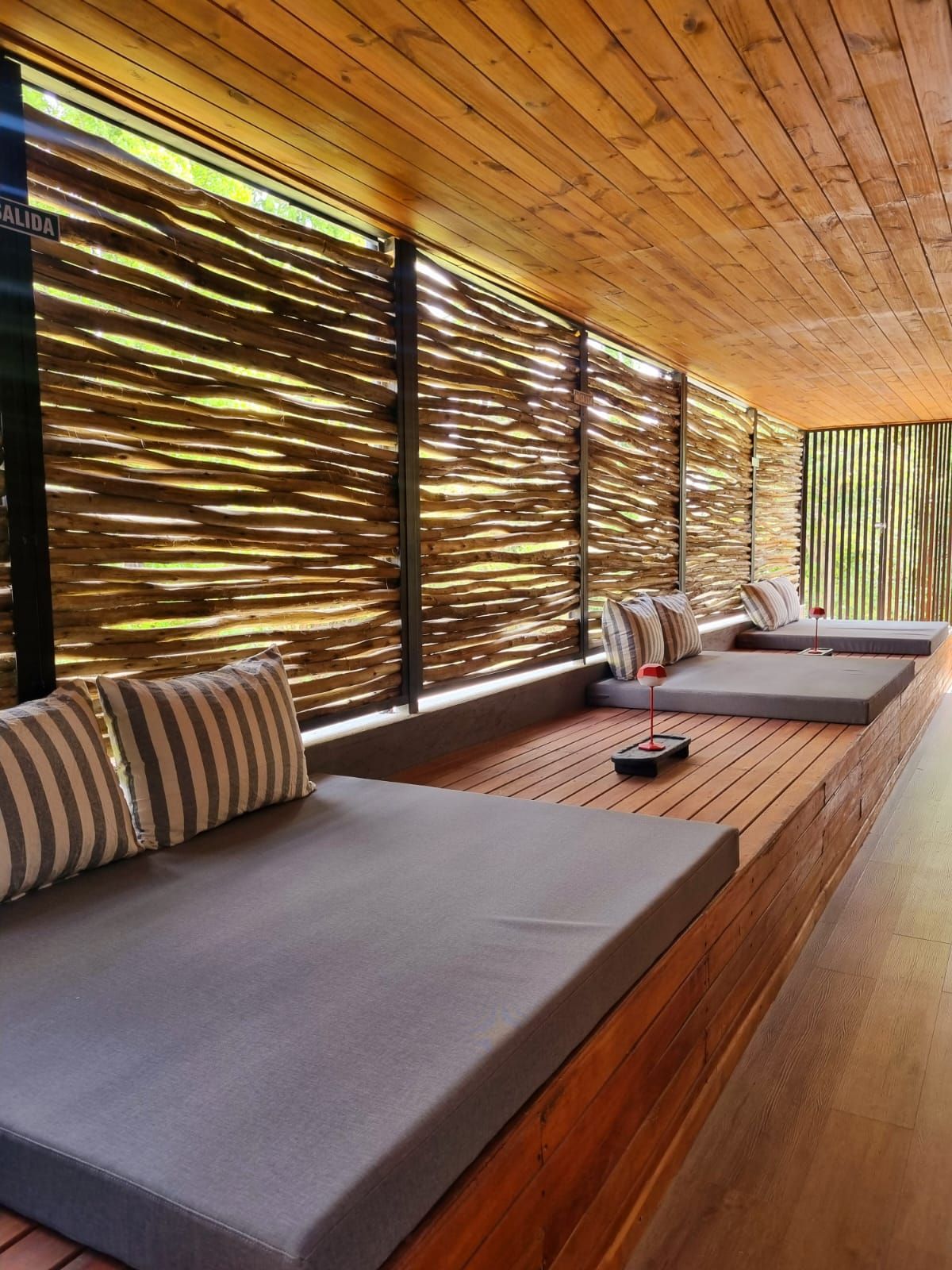 A modern outdoor seating area with wooden slats and cushions.