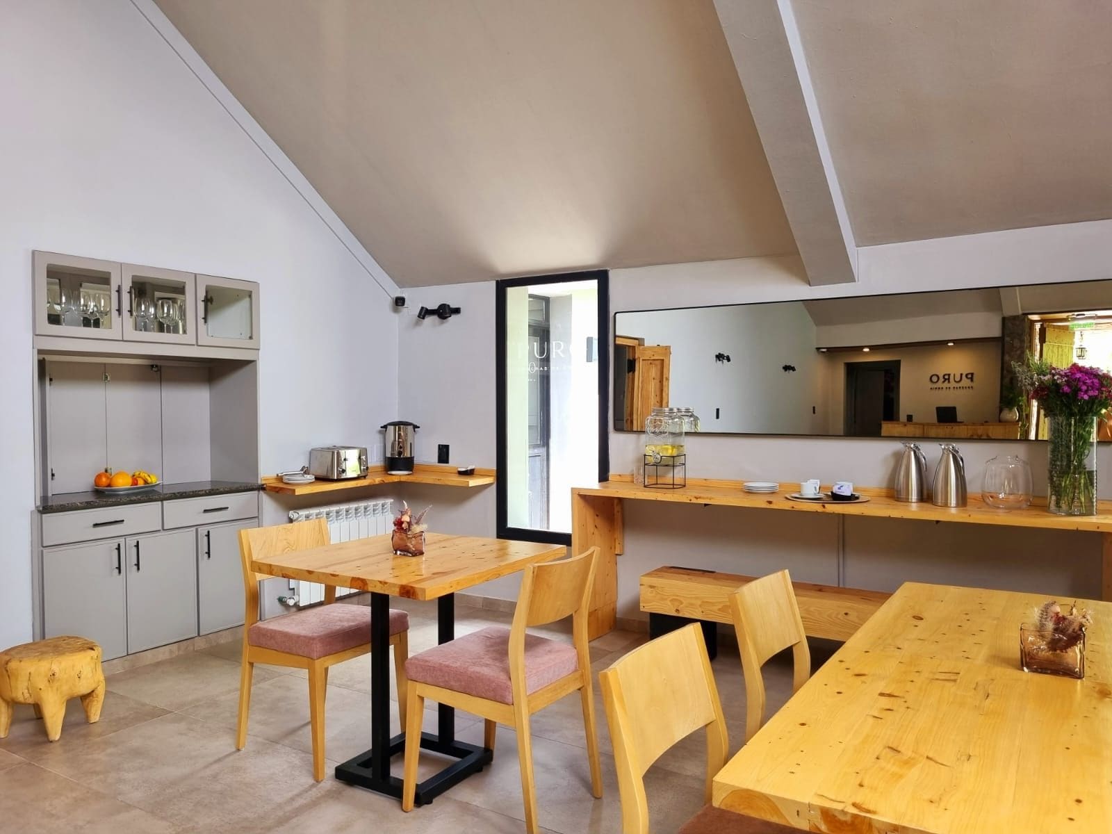 Una cocina moderna con comedor, que incluye una mesa y sillas de madera, una encimera con un tostador y vistas al área de estar.