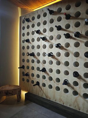 Una pared con varios portabotellas de vino.