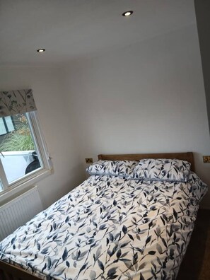 A bedroom with a bed, a window with a view, and a ceiling light.
