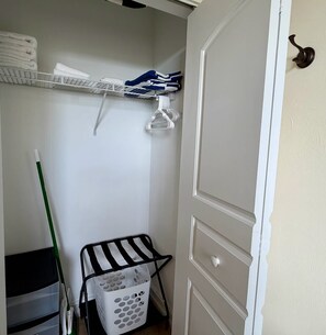 A laundry area with a drying rack, a basket, and a shelf with folded towels. - Bright Studio - Gulf Access - Bonita Springs (Bonita Springs)