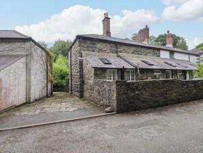 A stone building with a sloped roof and a small window. - Puffin Cottage (Bangor)