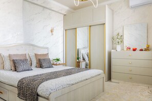 A bedroom with a bed, bedside tables, a dresser, and a mirror. - Apartments Piramit in Tashkent (Tashkent)