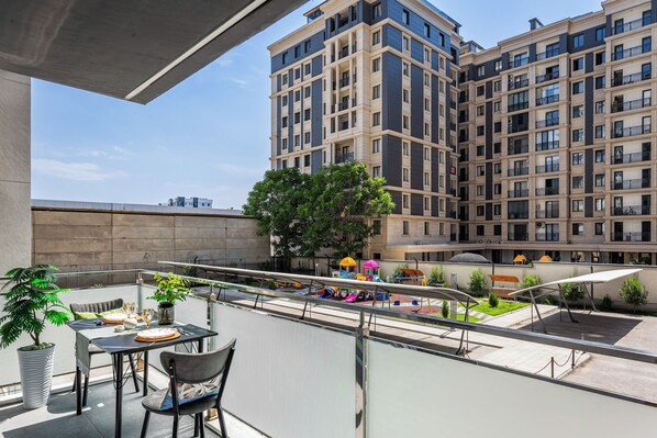 A balcony with a table, chairs, and a potted plant. - Apartments Piramit in Tashkent (Tashkent)