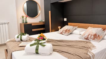 A modern bedroom with a bed, bedside tables, a mirror, and a nightstand.