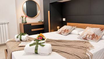 A modern bedroom with a bed, bedside tables, a mirror, and a nightstand.