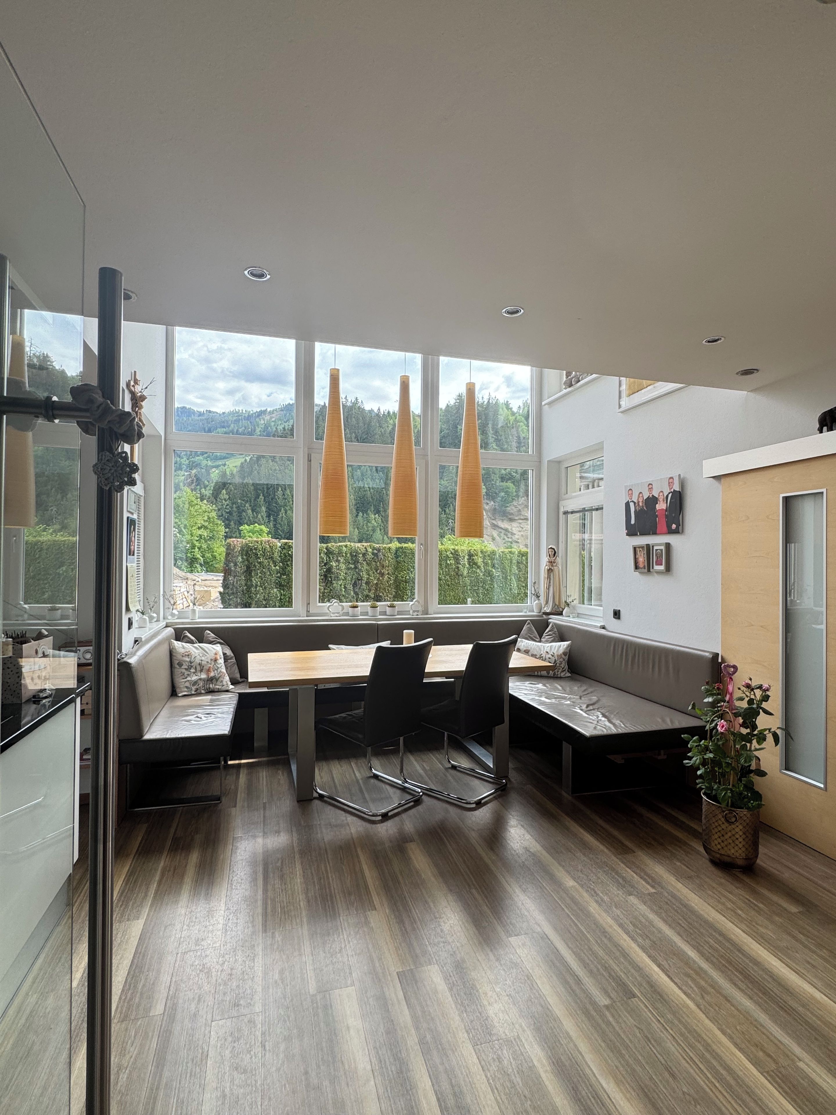 Una cocina moderna con comedor, ventanas amplias y vistas al exterior.