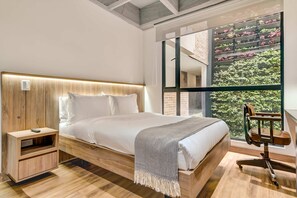 Ein modernes Schlafzimmer mit einem hölzernen Bett, einem Nachttisch und einem Sessel.