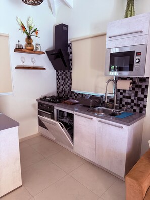 Een moderne keuken met een inbouwoven, magnetron en vaatwasser.