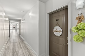 A hotel hallway with a door marked '409' and a 'welcome' sign. - Serene Waterfront Condo with Pool (Biloxi)