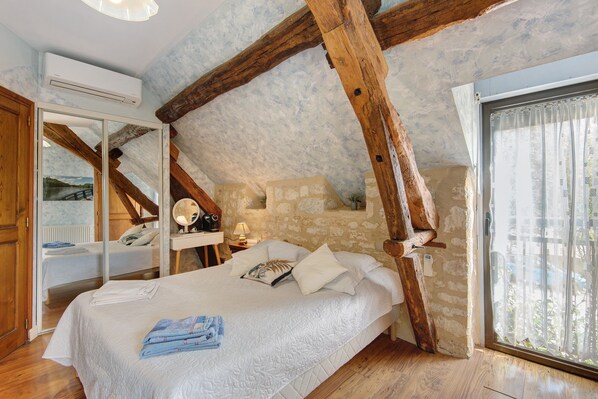 Une chambre à coucher avec un lit, un miroir, un bureau et une fenêtre.