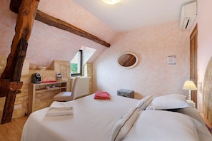 A bedroom with a bed, a small table, a chair, a radiator, and a window. - Room 'Chambre Romantique' with Shared Pool, Wi-Fi and Air Conditioning - Table d'Hôte (Salignac-Eyvigues)