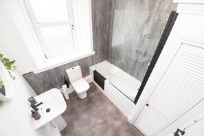 Ein Badezimmer mit Toilette, Waschbecken, Badewanne und Duschkabine.