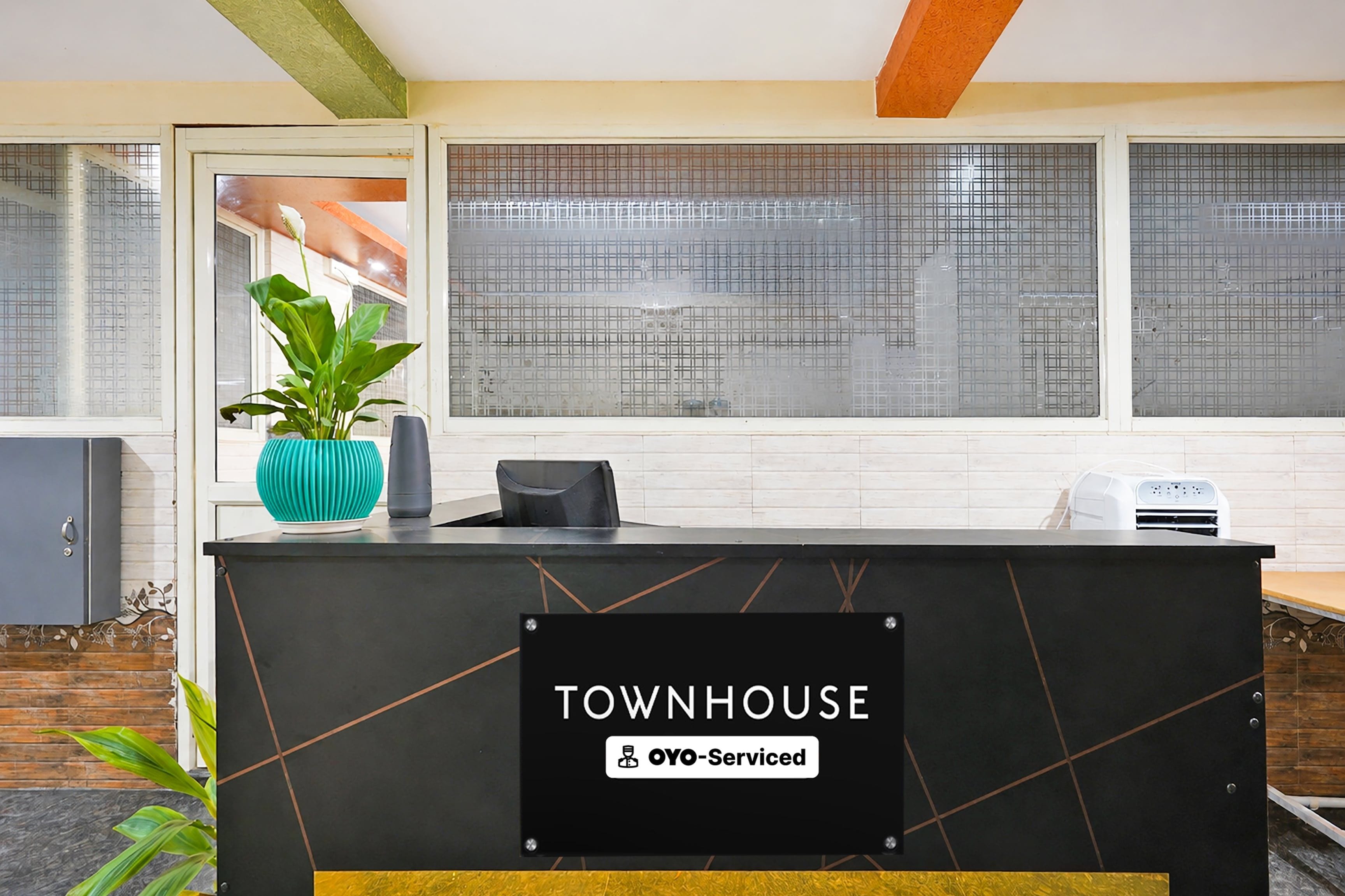 A reception desk with a sign reading 'TOWNHOUSE' and 'YOY-Serviced'.
