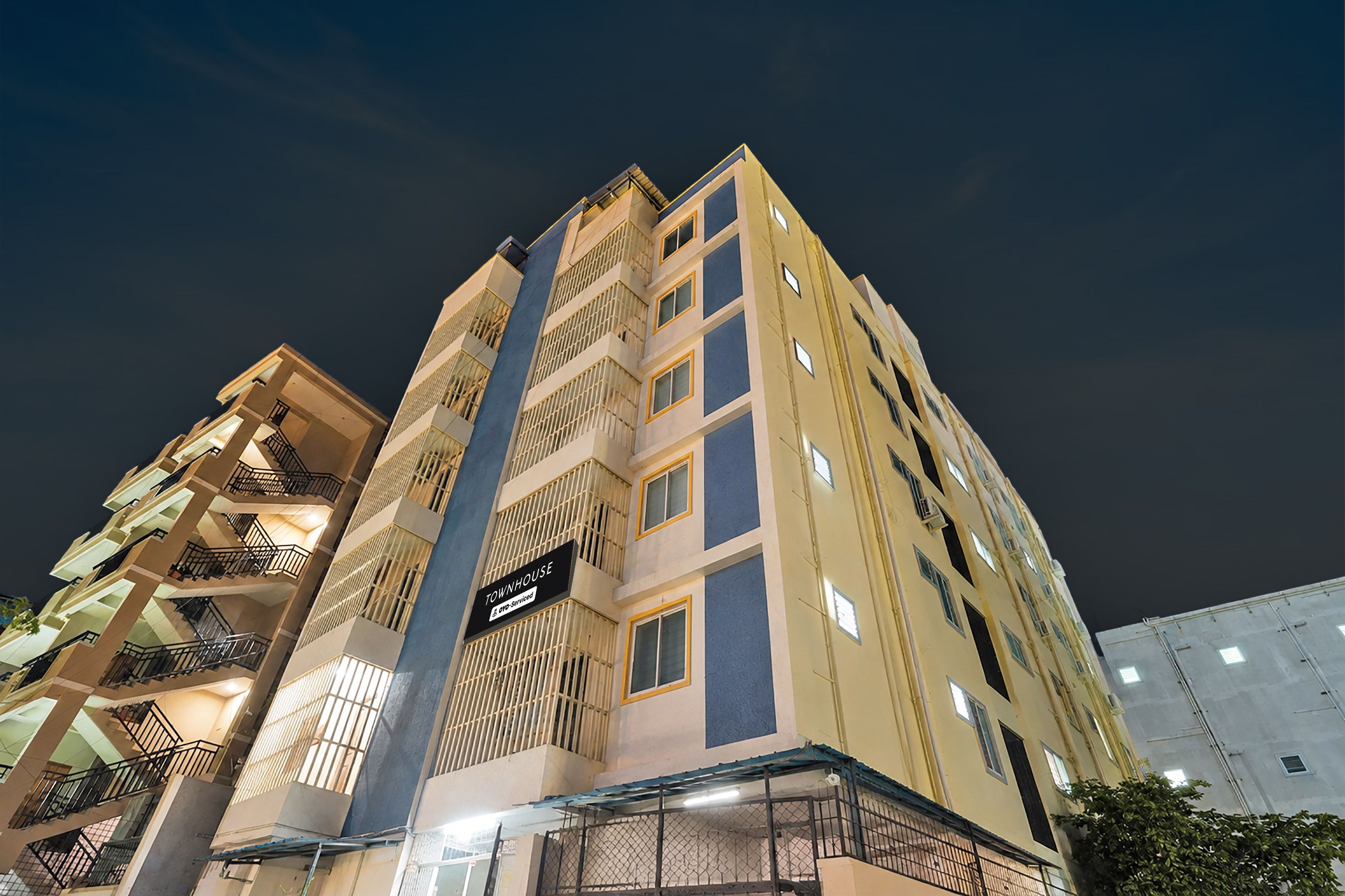 A multi-story building with balconies and a sign indicating it is a serviced apartment.