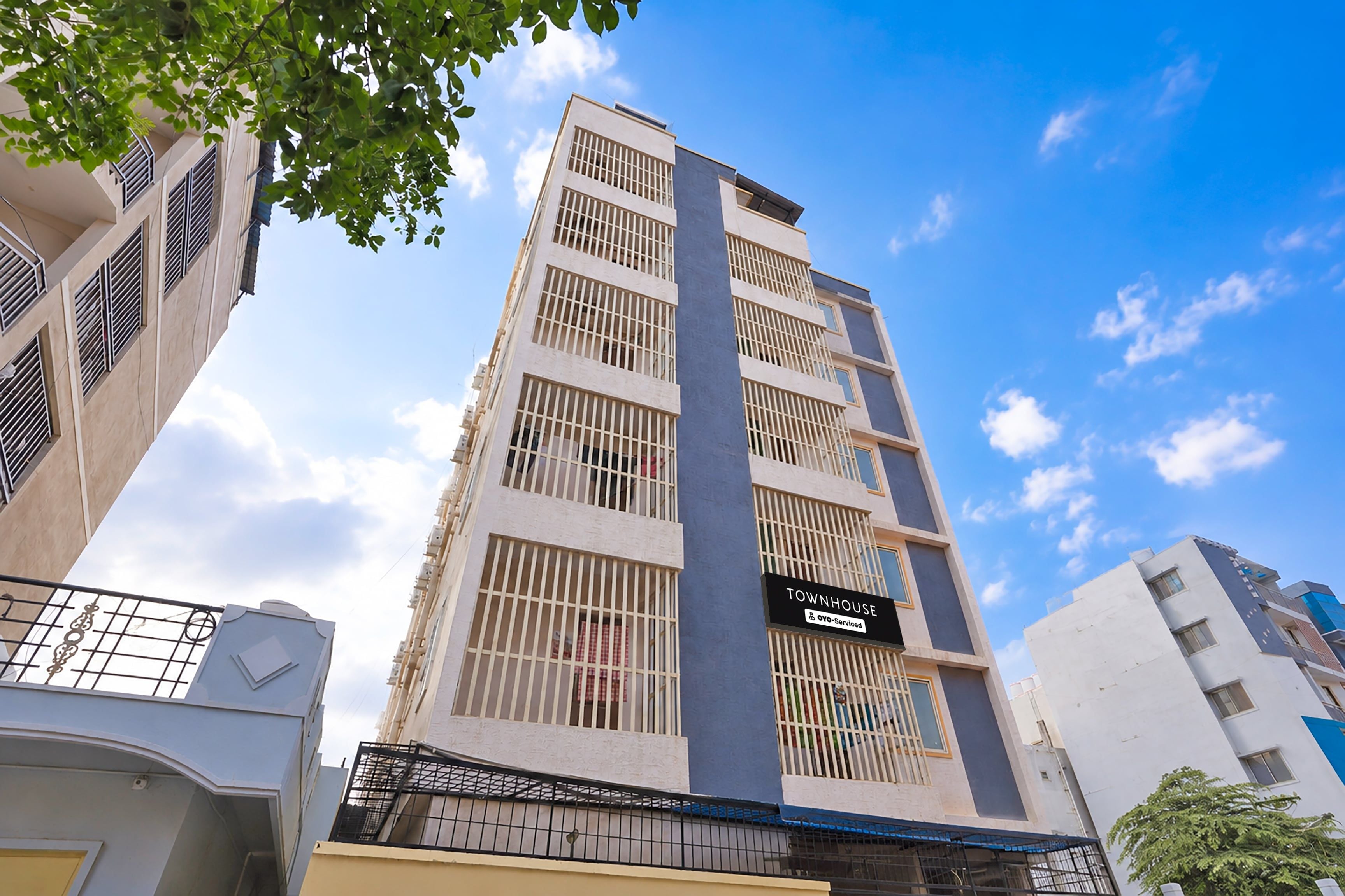 A multi-story building with a sign indicating it is a serviced apartment.