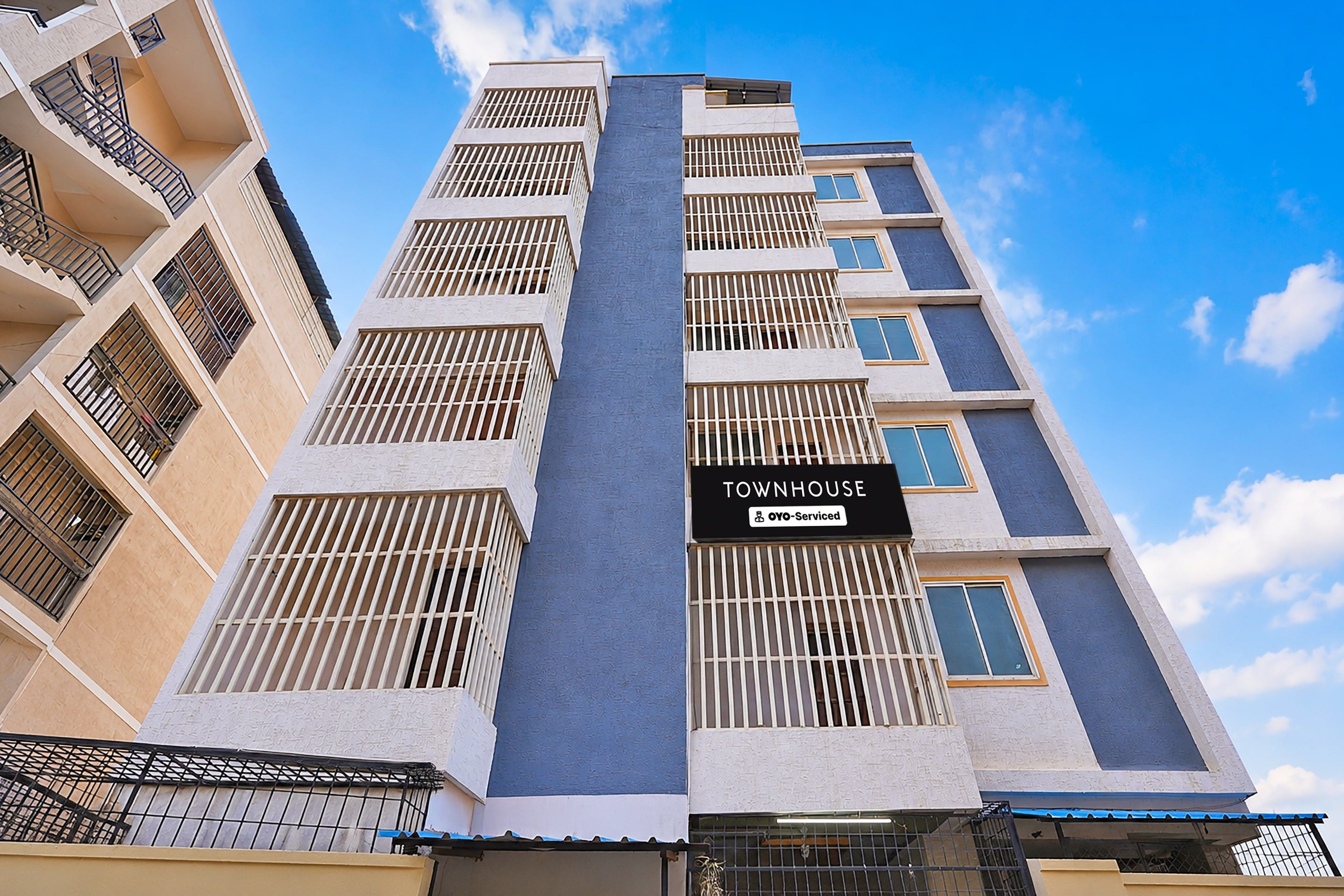 A multi-story building with a sign indicating it is serviced by OYO.