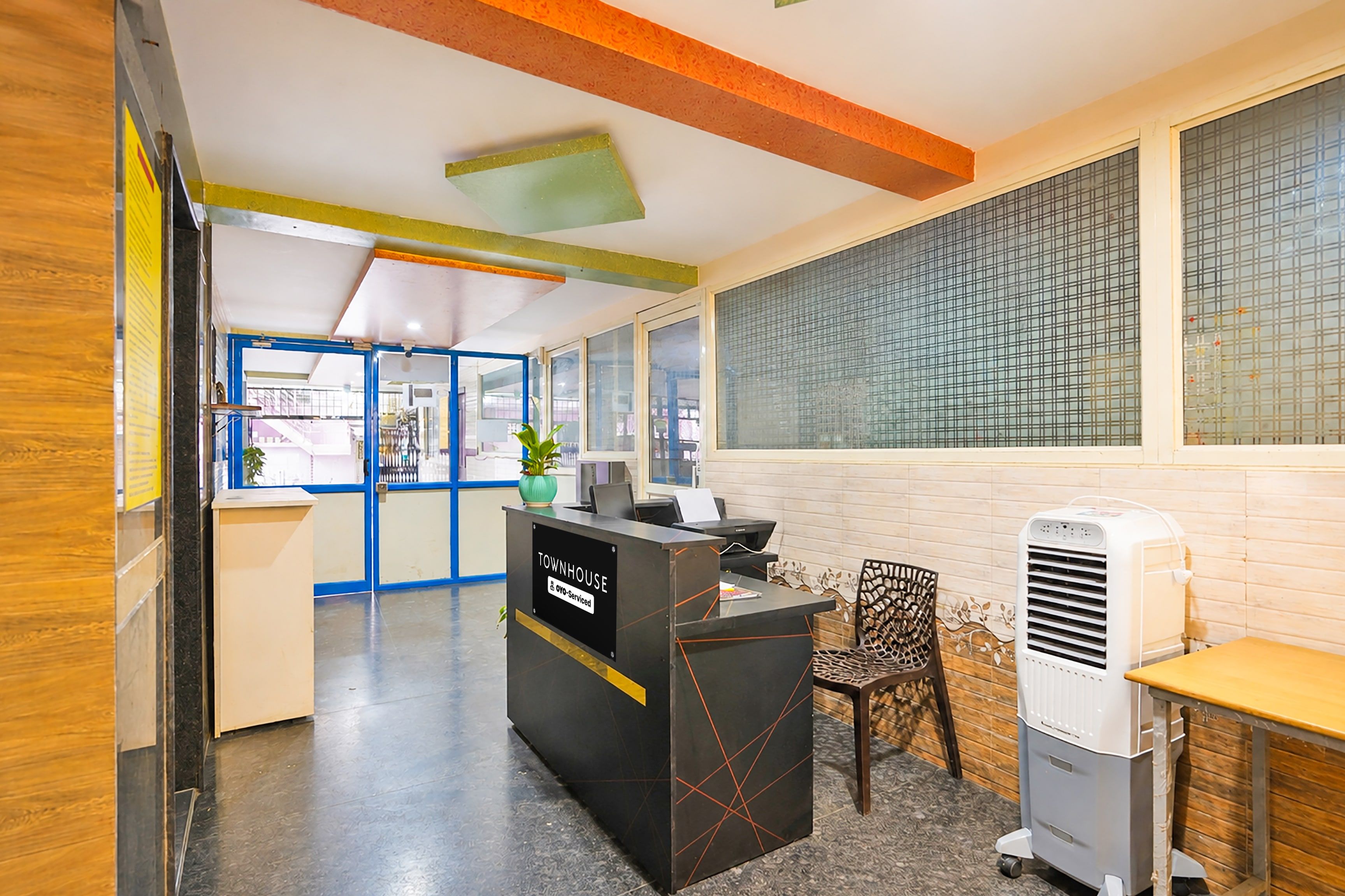 A reception area with a counter, a seating area, and a large window with a view.