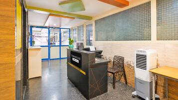 A reception area with a counter, a seating area, and a large window with a view.