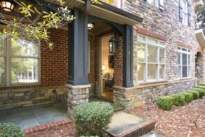 A stone house with a brick facade, a covered porch, and a well-maintained garden. - War Eagle Manor:Your Auburn Getaway (Auburn)